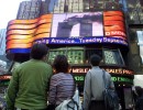 People gaze at a jumbotron in Times Square after the first tower of the World Trade Center was attacked on September 11, 2001.