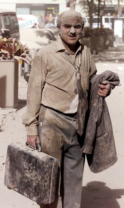 A man stands covered in dust on the morning of September 11, 2001.