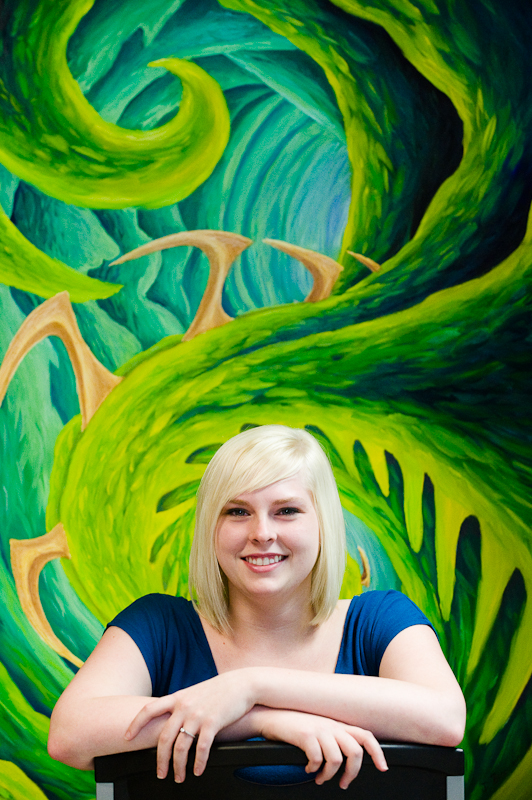 Jessica Boren poses in front of the eclectic art in the tattoo parlor where she grew up.