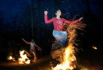 Gloria Emrani, 13, right, and Aida Emamghorashi, 8, left, leap over four consecutive fires during a celebration of the Persian New Year, or Norooz, in Greensboro on Tuesday, March 13, 2007. Jumping over the fire is supposed to cleanse the jumper so that they can start the New Year with a purified mind, body, and soul.