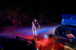 2014.  Oglala, SD.  USA.  A young woman pours out beer after the driver of her car was pulled over and arrested for a DUI.  She blew a 0.0 on the Blood-Alcohol reading and was let go after emptying all of the alcoholic beverages found in the car. Pine Ridge Reservation has a massive problem with alcoholism.  Although alcohol sales are banned on the reservation, the nearby border town of Whiteclay, Nebraska has four liquor stores, which sold over 4.9 million cans of beer in 2010 to mostly Oglala Lakota from Pine Ridge. Alcoholism is estimated to affect 85 percent of the families. (source: Wikipedia).