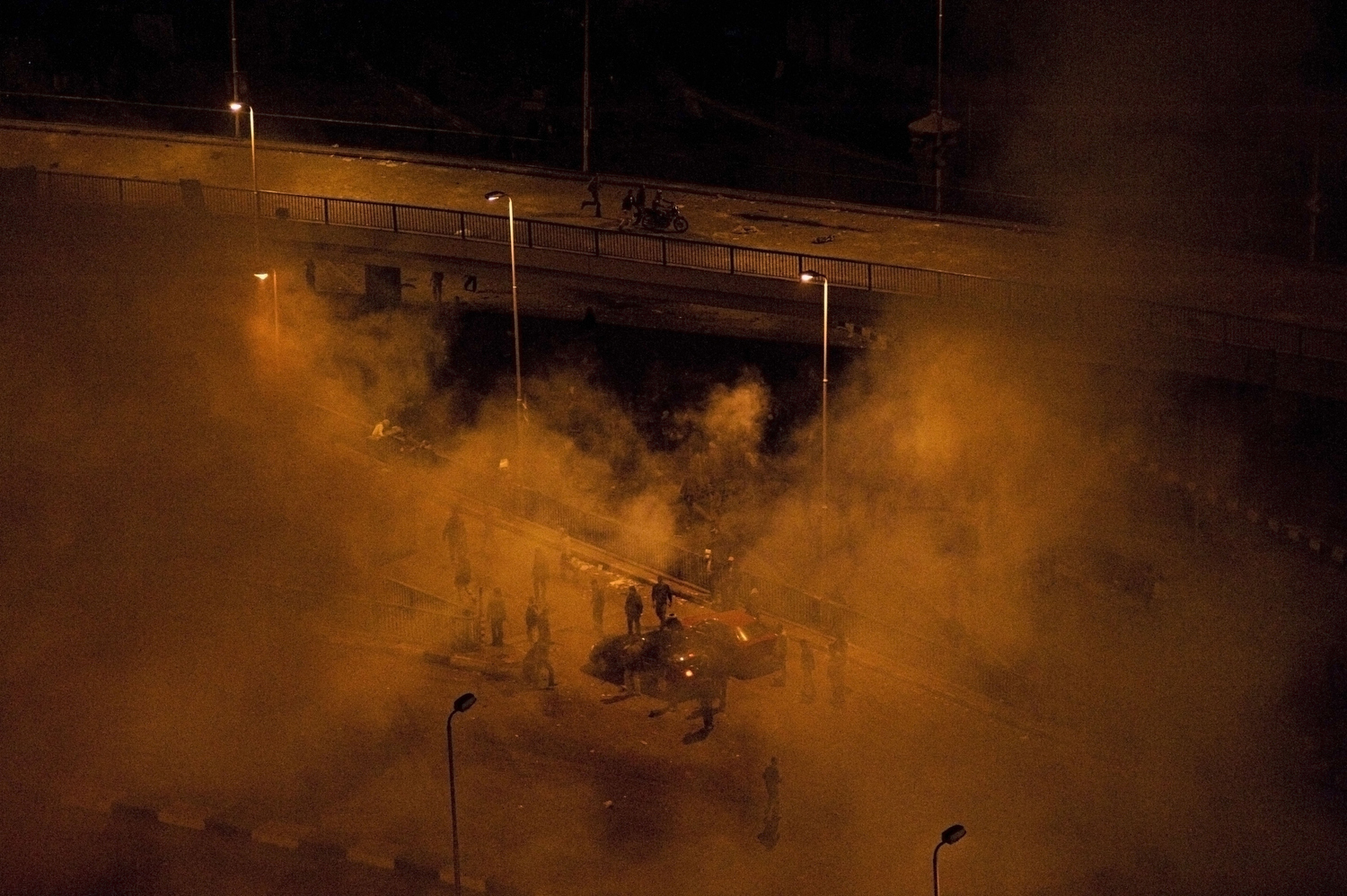 EGYPT.  Cairo.  2011. Mubarak supporters shrouded in smoke during all night classes by Tahrir Square.  