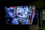 Picture of the TV screen showing live video from the International Space Station of astronauts returning to the ISS from a space walk