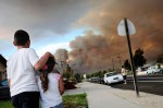Emilio Diaz Jr., 8, of Soledad holds his 4-year-old sister, Kiria, as they watch wildfires burn through the hills in east Soledad from their home along the 300 block of East Street. According to CAL FIRE Cpt. James Dellamonica, the Gloria Fire in Soledad was caused by agricultural fireworks, a type of sparkler used to scare birds and ground squirrels. 