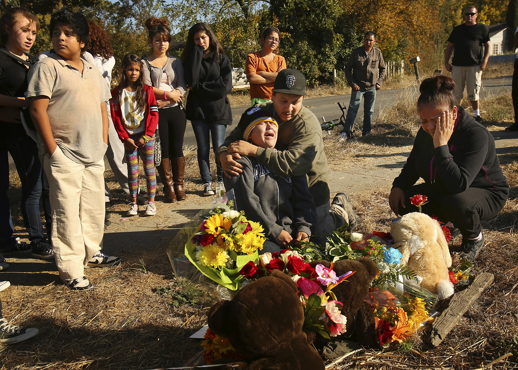 Sujey Lopez and her husband Rodrigo Lopez mourn for their son by a memorial setup at the site where 13-year-old son Andy Lopez was shot and killed by a Sonoma County sheriff’s deputy Tuesday afternoon near the corner of Moorland and West Robles avenues in Santa Rosa, October 23, 2013. (Conner Jay/The Press Democrat) 