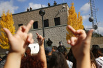 Protestors flip off Sonoma County Sheriff's deputies protecting their offices during a march in reaction to the death of 13-year-old Andy Lopez in Santa Rosa on Tuesday, October 29, 2013. (Conner Jay/The Press Democrat) 