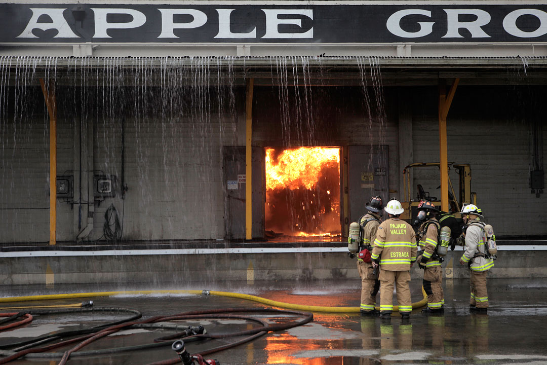 Firefighters try to contain a large fire that broke out in a building storing Martinelli's apple juice Wednesday in Watsonville. Authorities alerted Watsonville residents of a possible ammonia leak at the burning Apple Growers Ice and Cold Storage building, and cautioned the community of being exposed to any smoke. 