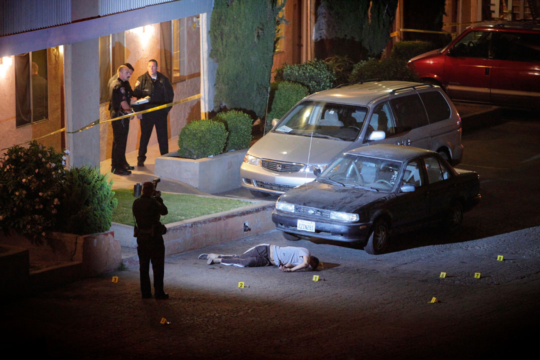 Salinas police officers and investigators mark evidence around the body of Francisco Hereida, 20, who was shot and killed in the parking lot of an apartment complex Auguest 30, 2011 along the 500 block of John Street night in Salinas. Hereida is the cities ninth homicide of the year and was one of four gang related shooting victims in the last five days in Monterey County. 