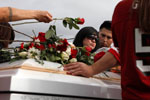 Diana Serrato, center, stands by her older brother Rogelio Serrato's coffin as friends and family lay flowers during his funeral January 13, 2011 in Greenfield. {quote}He didn't deserve this,{quote} said Diana. {quote}The sheriff killed the wrong man.{quote}