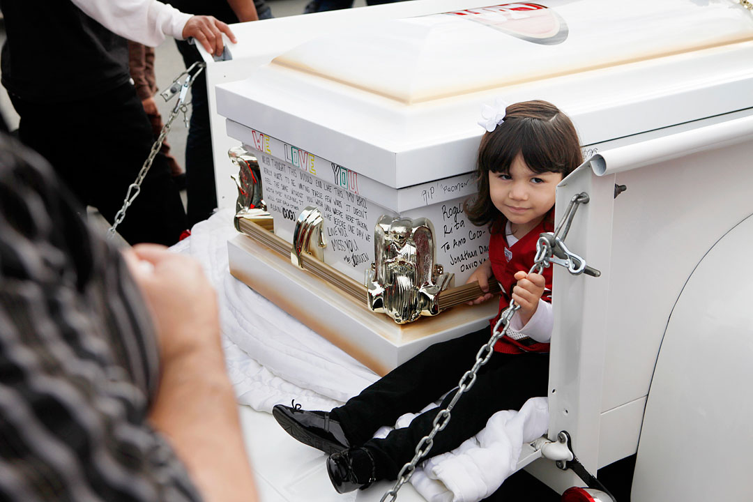 Kayla Armenta, 5, rides next to the coffin holding her uncle Rogelio Serrato during his funeral procession January 13, 2011 at Greenfield Holy Trinity Cemetery. 