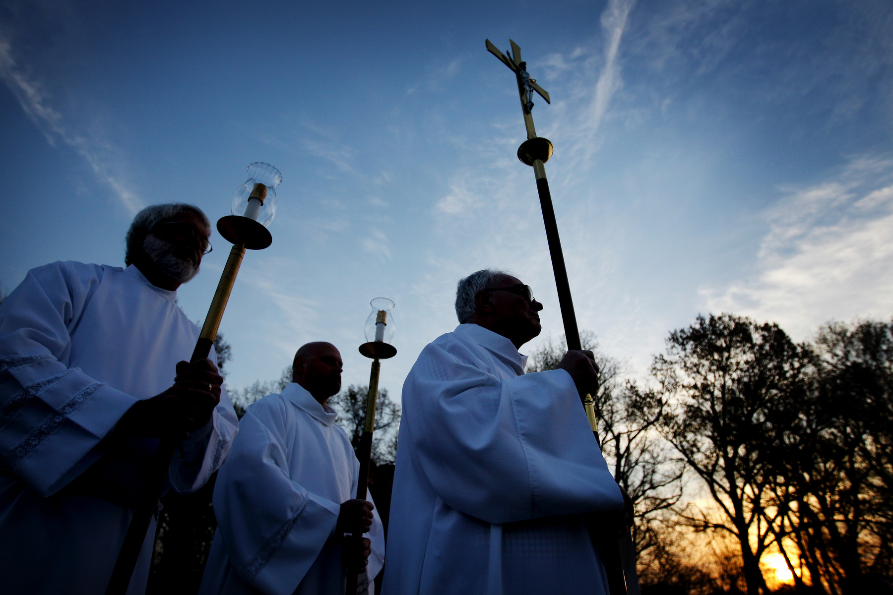 March 27, 2016 - As the sun rises Rick Martin (from left), Matthew Sorg and Bubba McArthur wait to lead the procession of the gifts of bread and wine to the alter during the 31st annual Easter Sunrise Mass at Calvary Cemetery. Hundreds of faithful filled folding chairs and camp seat, some bundled under blankets the celebrate Easter with the rising sun.(Mike Brown/The Commercial Appeal)