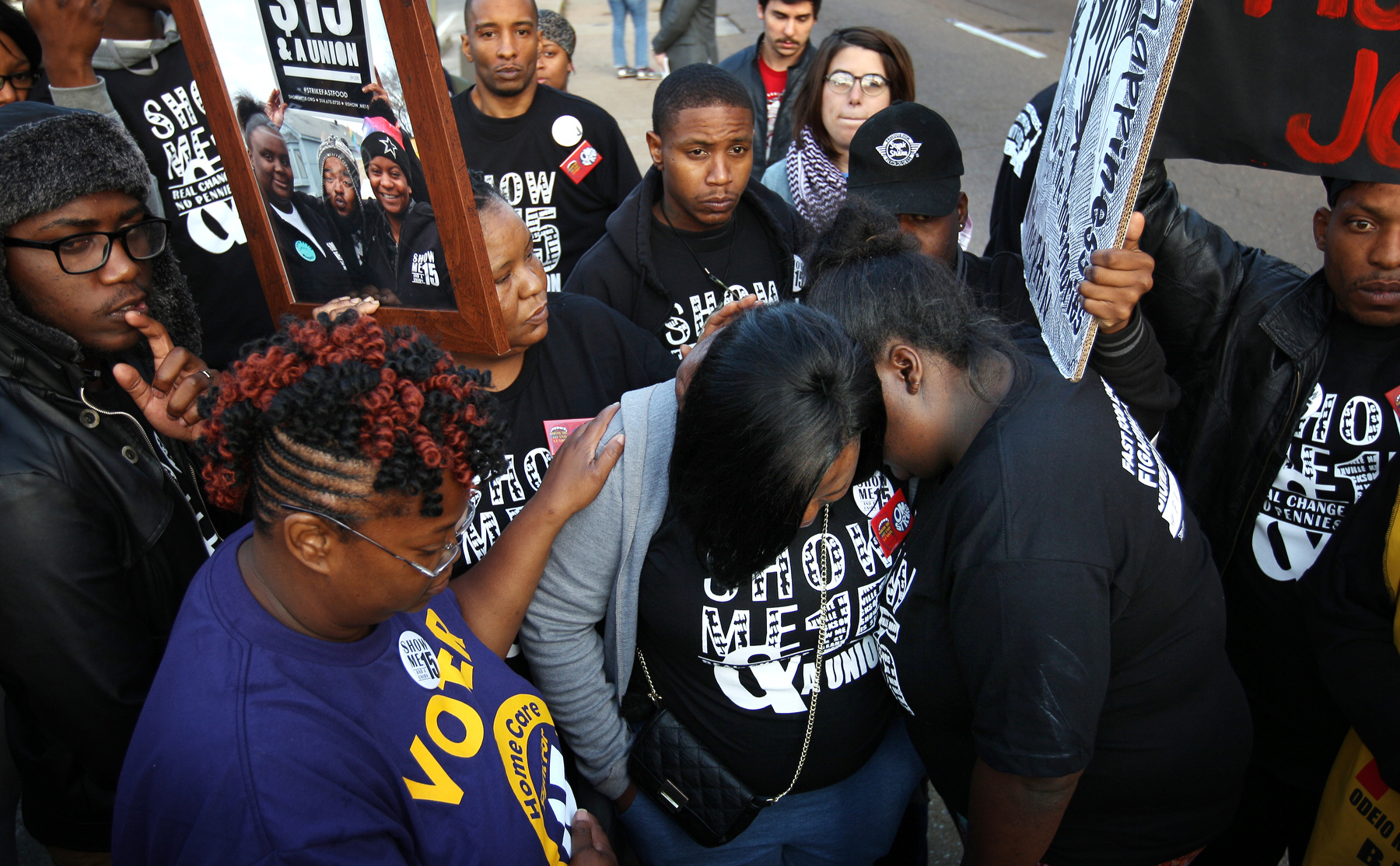April 14, 2016 - Protesters comfort Diaeatha Cathey (center) as they have a moment of silence and prayer for a fellow protester named Gerial Jeans who was found shot to death in an SUV on April 10. The protesters were gathered with the {quote}Fight for 15{quote} movement seeking higher wages for fast food workers. Jeans participated in past protests. (Mike Brown/The Commercial Appeal)