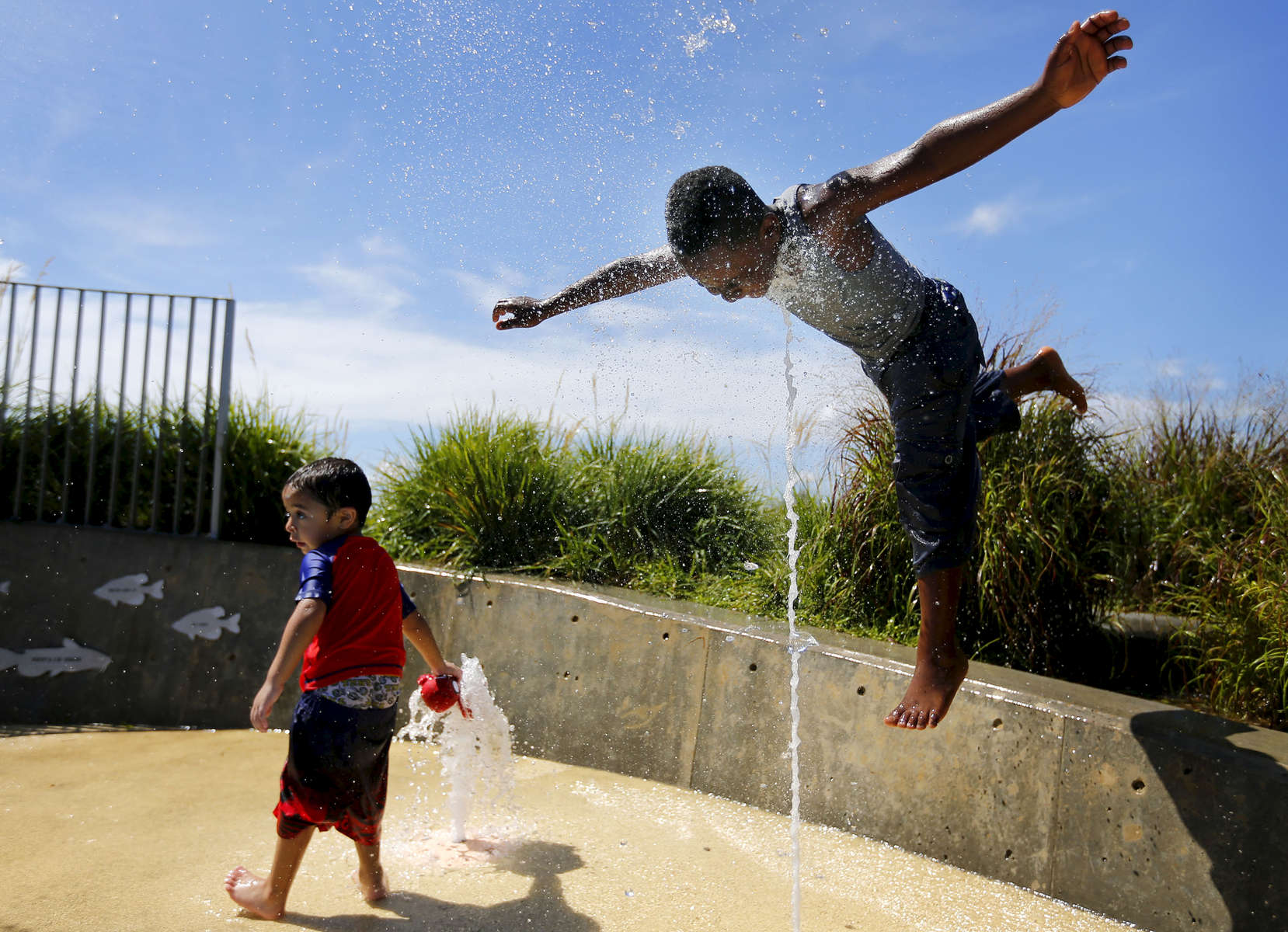 July 14, 2016 - Jahcquezz Payton (right), 8, lunges into a blast of water while Matthew Guevara, 3, soaks his stuffed animal while keeping cool in the water on Island Play at Beale Street Landing. (Mike Brown/The Commercial Appeal)