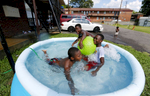 July 26, 2016 - Tarion Johnson, 8, (from left) DeAntonio Jackson, 9, and Royce Jackson, 10, goof off while staying cool in a small pool outside their apartment complex on Danny Thomas near Georgia. According to the National Weather Service the heat index topped 105 degrees. (Mike Brown/The Commercial Appeal)