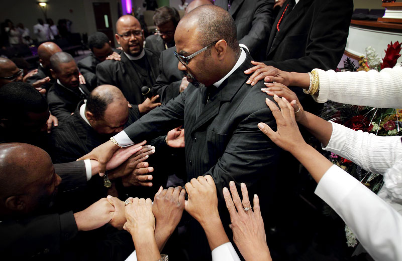 November 4, 2012 - Members of the congregation at Greater Community Temple pray over their pastor Bishop Brandon B. Porter during the 10 a.m. Sunday service at the church's Winchester location. Porter is seeking election to the Church of God in Christ general board during the annual convocation in St. Louis on November 13. (Mike Brown/The Commercial Appeal)