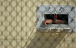 A detainee's arm hangs outside his cell within Camp Delta's Camp 4 medium security prison. The men within Camp 4 are considered compliant, meaning they provided credible information and have conformed to prison rules. As a reward they live, eat and pray in a communal setting.(© Mike Brown)