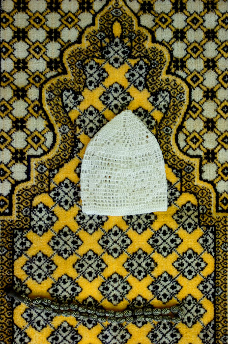 Prayer beads and a prayer hat sit on a detainee's prayer mat within his cell in Delta Camp 4 within the prison at Guantanamo Bay. Delta Camp 4 houses the medium-security, compliant detainees (approximately 34% of total population).(© Mike Brown)