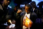 A gang member shields his candle from the wind and rain outside the National Civil Rights Museum during a candle light vigil to honor victims of violence as part of the Southern Christian Leadership Conference event on the eve of Martin Luther King Day. Individuals from the four major black gangs operating in Memphis attended.(Mike Brown/ Memphis Commercial Appeal)