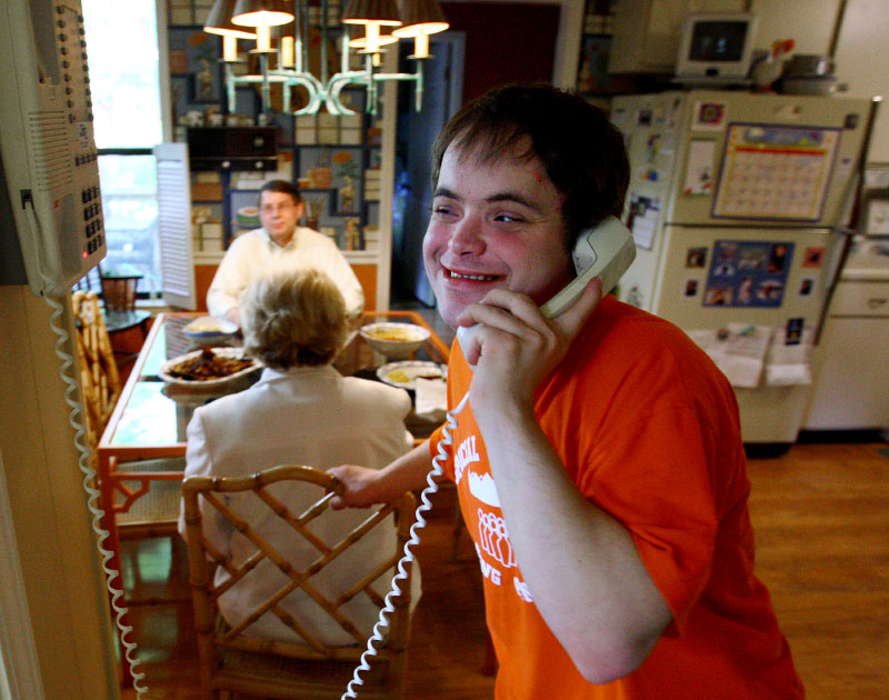 Kenny Thielemier takes a quick break from the dinner table with his mom and dad, Nancy and Ken, to catch a phone call from one of his friends. He hopes to get his drivers licence, get married and eventually live on his own.