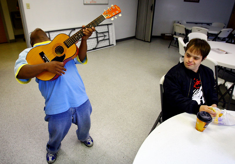 Kenny Thielemier gets a morning serenade from classmate Danny Munson, 20, as he eats his breakfast at the Good Life Center, a nonprofit day program operated by the West Tennessee Family Solutions. At the program Kenny learns skills that can be applied to his janitorial job along with performing community services.