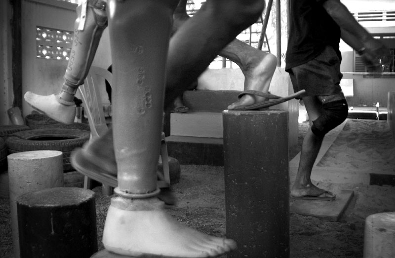 Men wounded by land mines are trained to walk with their new prosthetic legs at Handicap International in Siem Reap. The UK-based organization provides prostheses and training for victims of land mines free of charge.(© Mike Brown)