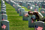 May 29, 2011 - Mary Coleman weeps as she embraces the headstone marking the grave of her mother and father, Robert and Mary Cole, at the Memphis National Cemetery on Sunday. Her father served in the Korean war with the Army. The cemetery hosted its annual Memorial Day Service on Sunday.(Mike Brown/The Commercial Appeal)