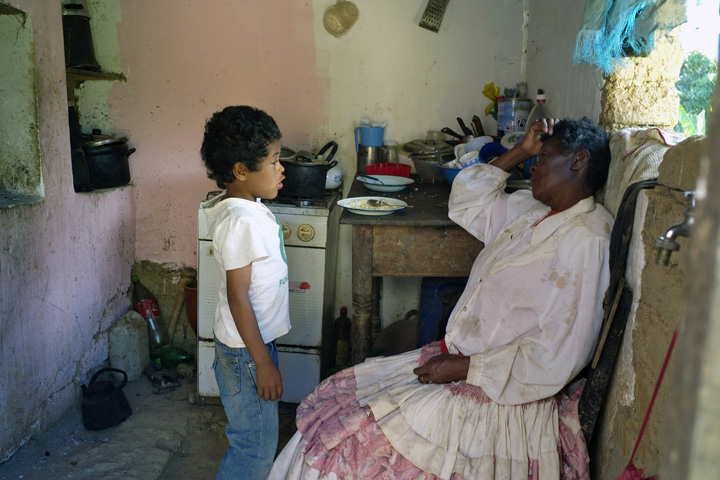 Exhausted from working in the field Ms. Vasquez talks with her grandson. 