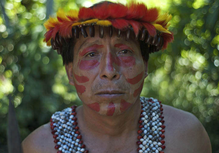 Arturo Kinin, an Awajun wearing warrior attire, works as a history teacher in the area. Kinin expressed disgust with the Peruvian government which he stated has not provided medical assistance or compensation to victims of a police attack on protesters. Local plants with healing properties are being used to treat gunshot wounds, according to Kinin. 