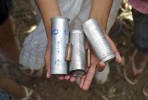 An Amazonian girl holds empty tear gas canisters and bullet shells she found on charred grounds where indigenous natives and local migrants clashed with Peruvian national police. 