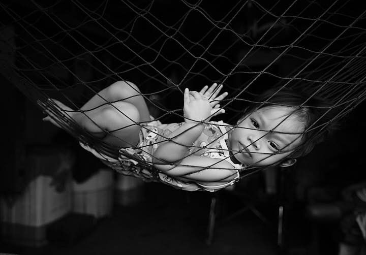 Catriona Zamora, two-years old, relaxes in a rope mesh hammock. 