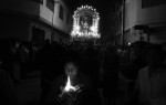 A boy lights a candle as he joins a procession for Senor de los Milagros (Our Lord of Miracles).