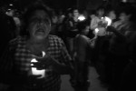 A woman sings as the procession passes through her neighborhood.
