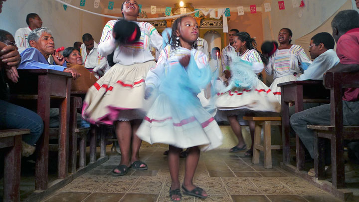 An Afro-Bolivian dance troupe performs for churchgoers during a celebration marking a religious festival ('Fiesta de San Benito').