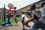 Several local boys make do with a toy basketball goal and high spirits.