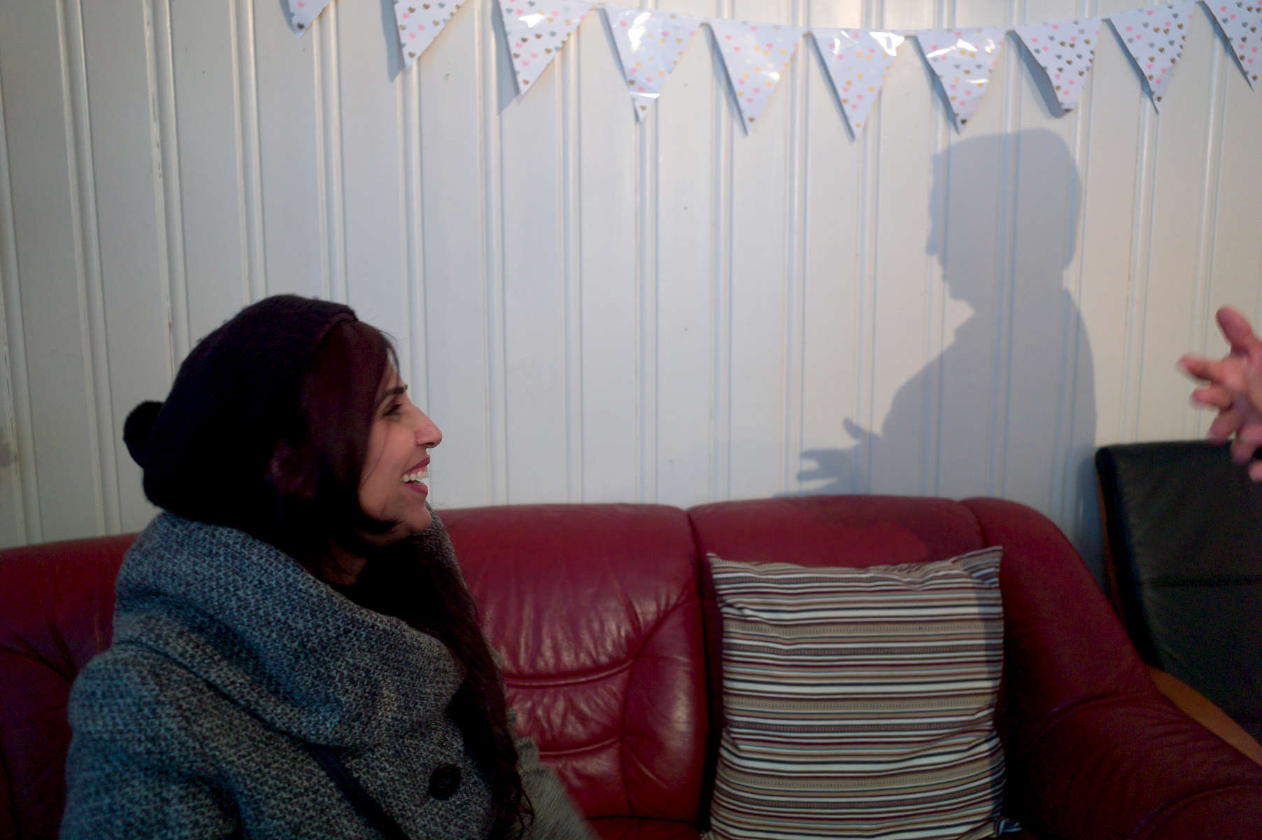 A rejected asylum seeker sits on a sofa talking to an Arabic woman whose only image is that of the shadow she cast on a wall.