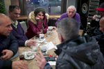 A rejected asylum seeker sitting at a cafe table with six Arabic men listens as one of them proposes marriage.