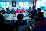 A group of people in a conference room discuss the plight of rejected asylum seekers.