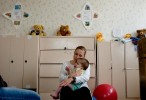 Karen Hairston, a volunteer with the Human Touch Project and a physical therapist at Children's Therapy Services in Fayetteville, Arkansas, tries to comfort Sveta, 3, who cries whenever she is held. Three of Hairston's patients in Arkansas are former Ukrainian orphans with Cerebral Palsy.