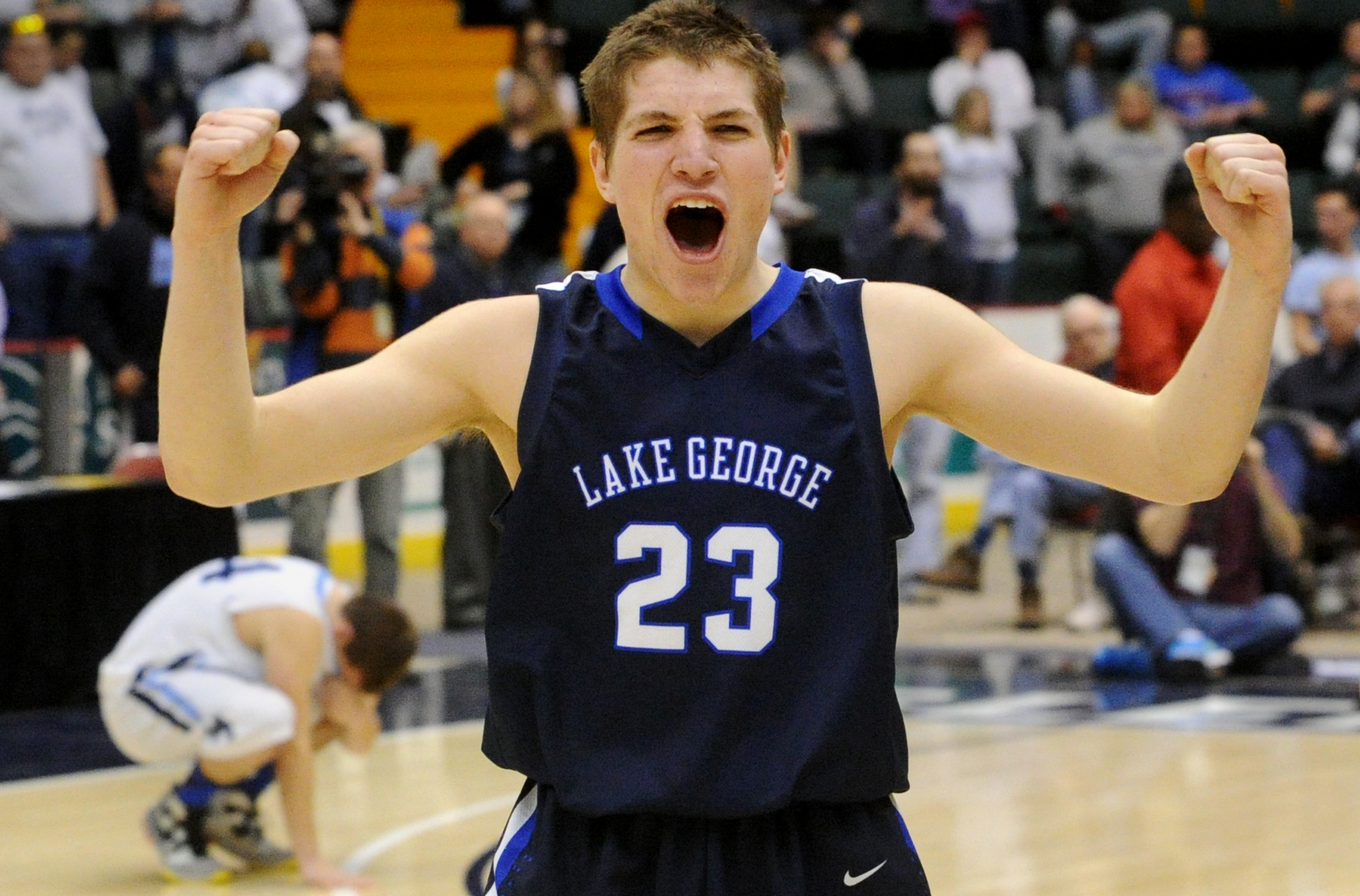 Lake George senior Greg Rosenthal celebrates his team\'s 68-61 overtime victory as a Moravia player reacts to losing in the Class C semifinal game of the State Boys Basketball Tournament at the Glens Falls Civic Center on Friday, March 15, 2013. Lake George will play Pine Plains in the championship game on Saturday at 7:15 p.m.(Jason McKibben - jmckibben@poststar.com)