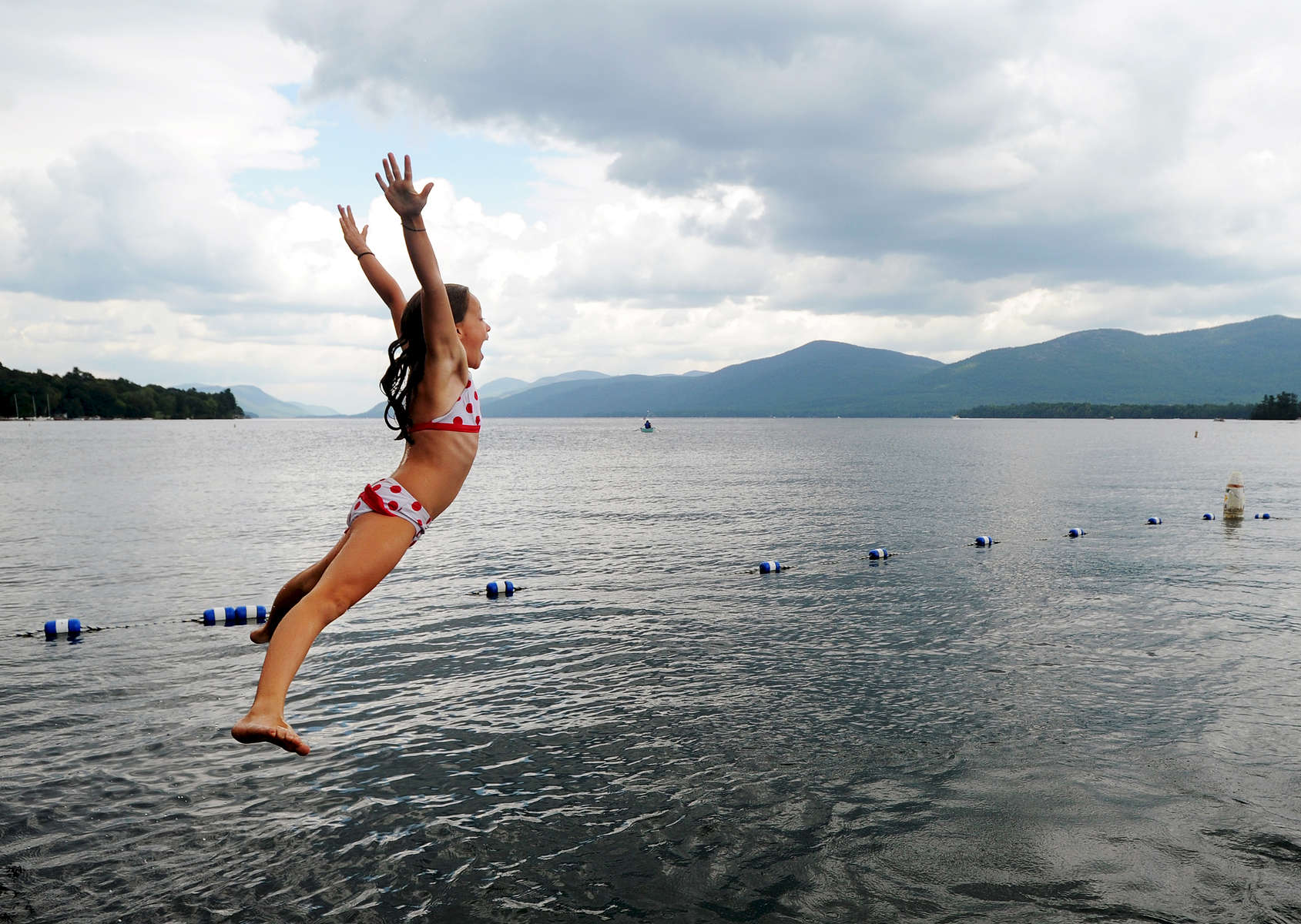 Alice Fox, 9, leaps off the dock and into Lake George at Diamond Point Beach Tuesday, August 28, 2012. Fox was swimming and practicing diving with her sister, Ella, and their mother at the beach as the sun went in and out of the clouds. (Jason McKibben - jmckibben@poststar.com)