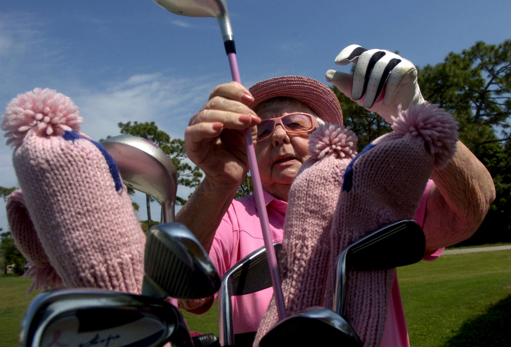 Ruth Wagner of Port Charlotte pulls a pink-shafted golf club from her bag at the Venice East Golf Club Wednesday afternoon, March 5, 2008. Wagner lives in a pink home and estimates that about 80% of her wardrobe is pink now that she's retired. {quote}I wore so much dark colors in business - brown, black... they didn't like pink.{quote} She hits the links twice a week and also enjoys mahjong and bridge. {quote}I'm not a sit at home type. I don't want to watch the box,{quote} she said. 