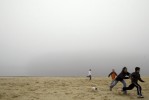 Heavy fog hangs in the air above Round Valley Reservoir Wednesday afternoon.  Playing some football on the beach after a half day of school are Samantha Beadle (age 13), Ryan Beadle (age 7), Brandon Puc (age 7) and Max Mead (age 7).  Callie the dog chases after the kids. Photographed for The Star-Ledger