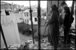 Sejoud Toubasi and her mother Aida talk with a neighbor through the destroyed third floor wall of their home in Jenin Camp on the West Bank.  The camp was devistated during fierce fighting between Palestinians and Israeli forces in April 2002. 