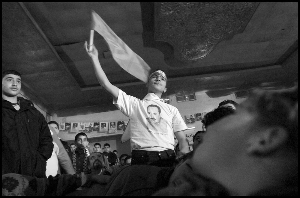 A young man holds up an PFLP flag at a rally in a cinema in Damascus, Syria. 