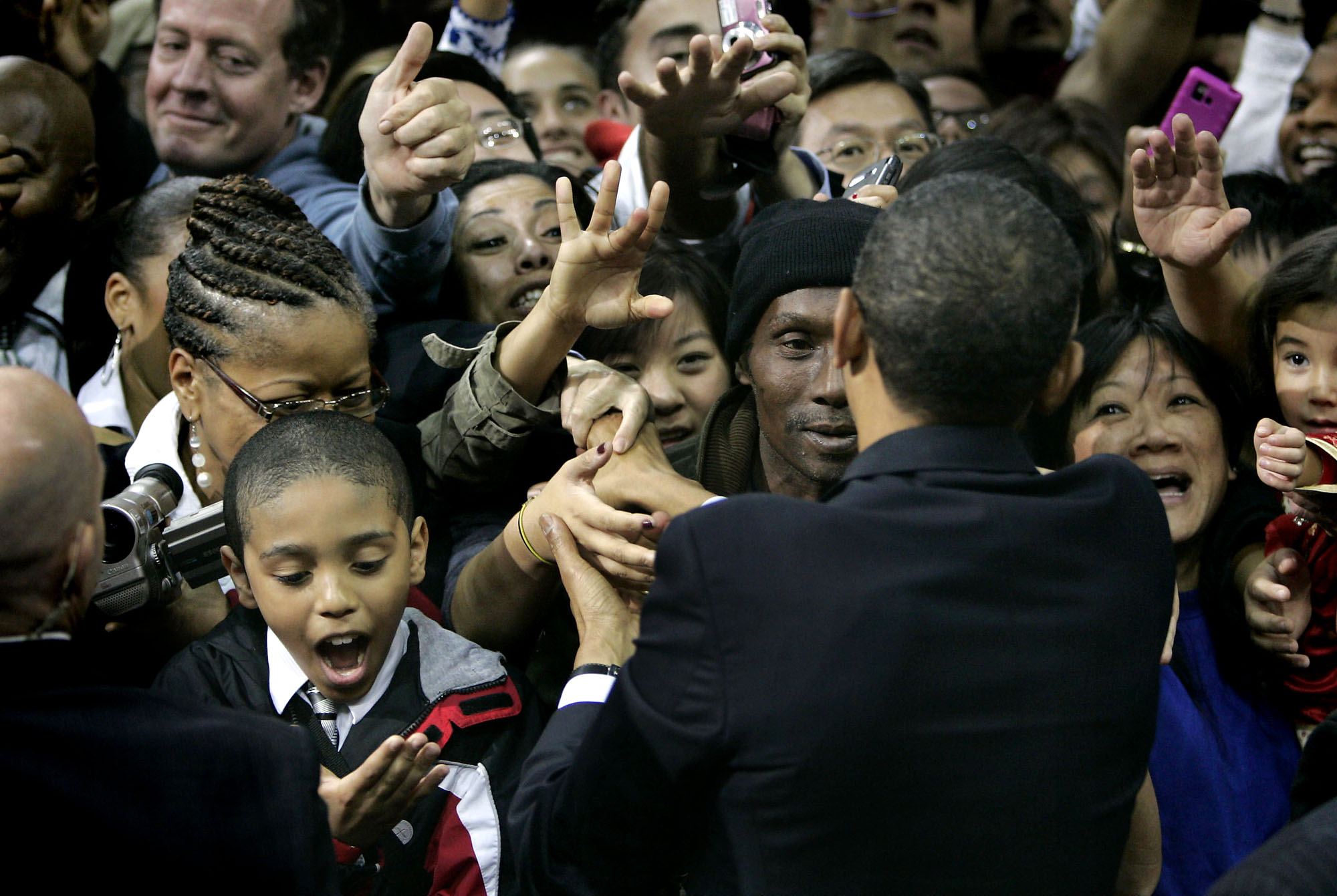 A young boy looks to his hand in awe after shaking it with U.S. President Barack Obama during a Newark, NJ campaign rally for NJ Governor Jon Corzine.  Photographed for The Star-Ledger