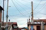 A man stands on a rooftop below a handmade electrical grid hanging over a Roma village, as people turn up to vote in October's Parliamentary elections in the nation's capital, Sofia. Today, October 5th, 2014, is also Midterm Elections day in the States - its multi-party ticket an unimaginable reality in autocratic Bulgaria pre-1989. Despite a month-long vacillation on the make-up of their political coalitions and their new prime minister - and that only 49% of the population turned up to vote today - party leaders narrowly avoided reelections, with former prime minister and leader of center-right party GERB Boyko Borisov reinstated at the post.