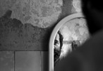 A patient stares at himself in the bathroom mirror of the psychiatry ward of a county hospital in Bulgaria on August 30, 2007. 