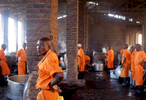 Prisoners rest in between cooking food via peat and biogas at Rwamagana Prison in Rwamagana, Rwanda, on November 18, 2017. All of Rwanda's prisons use their prisoners' waste - in addition to that of cows - to fuel their kitchens via biogas. At Rwamagana, biogas is used to cook corn, and peat cooks rice and beans. Many prisoners say they can usually tell when biogas is used due to the lack of smokey flavor in food. Nearly half of all Rwandans live in poverty, relying on small-scale farming for survival without gas or electricity. With so many women and children spending hours of the day foraging for wood used for cooking and light, often damaging their eyes, lungs, the forests and atmosphere, a little inventiveness helps. Enter cow and enter pig -- not just as a source of food, but also the heat needed to cook it. Or more specifically, their poo -- the fuel fed to a biogas digester, a tank that converts organic waste into methane. 