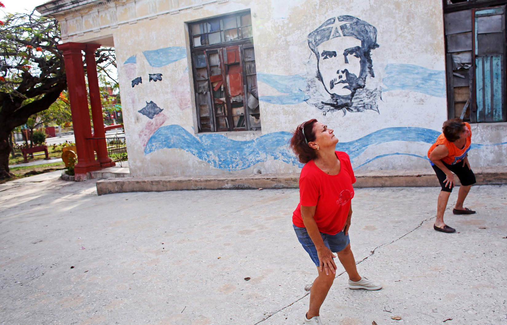 Women practice Chen-style t'ai chi ch'uan under a fresco of Cuban revolutionary philosopher and political theorist José Martí and communist revolutionary leader Che Guevara in Mariel, Cuba. Images of government idols - a famously ubiquitous sight across Cuba - fill the space that an absence of advertising leaves in printed media, billboards, and edifices.