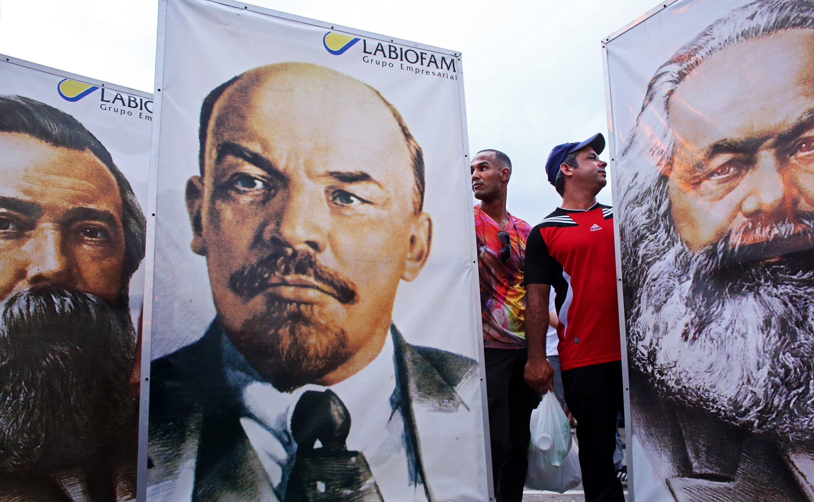 (L-R) Participants in the 1st of May Labor Day parade march in Havana, Cuba, hold signs of German Communist revolutionary Friedrich Engels, Russian Communist leader Vladimir Lenin and German Communist revolutionary Karl Marx. In Cuba, the day known as Día del Trabajo is a call for people to show support to their socialist government and the Cuban Revolution. Guests worldwide are known to join. While attendance is not mandatory, absence from the march is usually noted and discouraged. I recall the communist years Labor Day marches of Bulgaria quite well: much like in the Cuba of today, groups of people huddled with their co-workers in the early a.m hours, attendance to be accounted for by their boss - or face social, and often professional, retribution.  